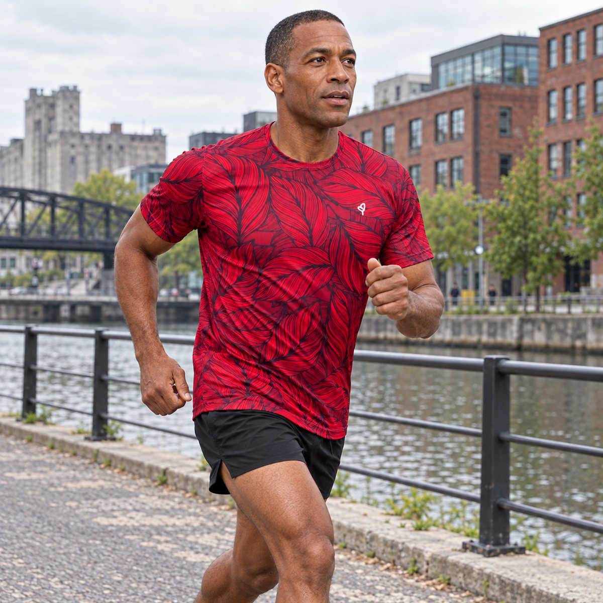YUL Crimson Red men's running shirt, red and black, worn by a runner beside a canal.